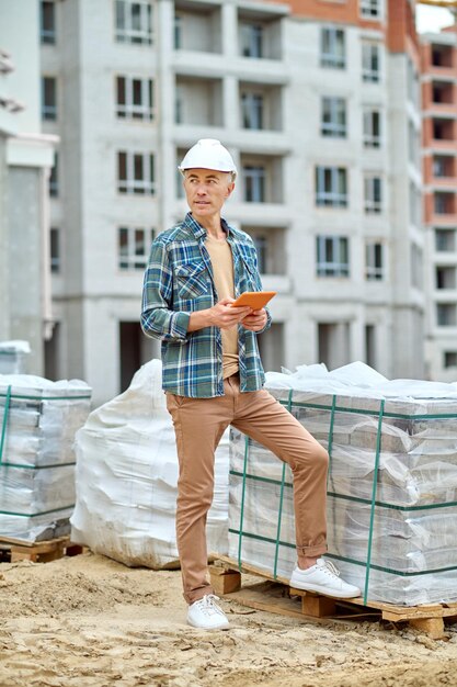 idea adult man protective helmet plaid shirt with tablet his hands thinking looking side standing construction site_259150 57618